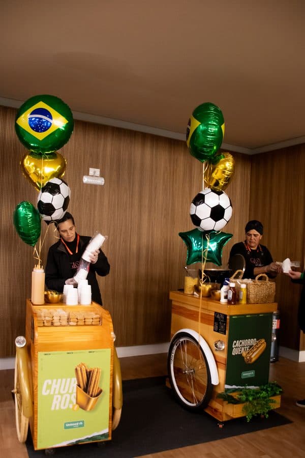 Dois carrinhos da Glow decorados com balões verde e amarelo em ação interna de empresa